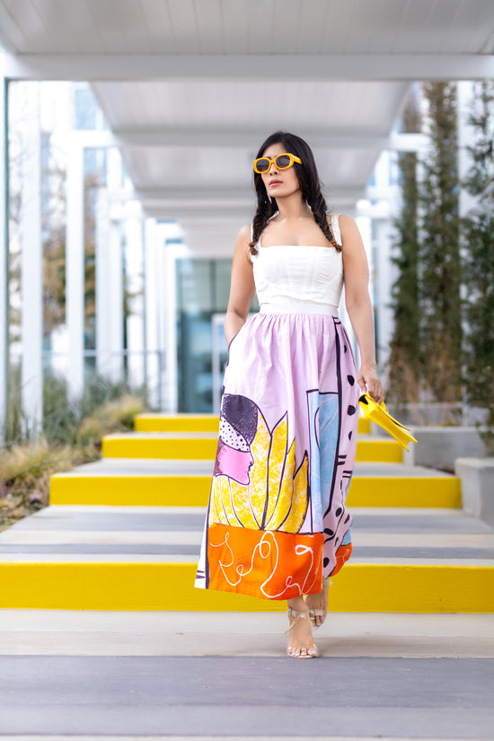 Model walking wearing POISE abstract wearable art midi skirt by Ojasi, luxury designer statement skirt with colorful artistic print and modern silhouette