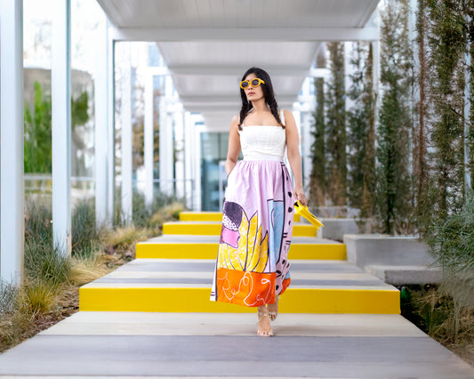 Model walking wearing POISE abstract wearable art midi skirt by Ojasi, luxury designer statement skirt with colorful artistic print and modern silhouette