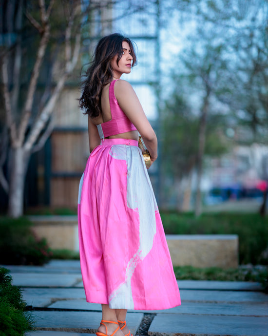 Blush pink and ivory printed raw silk skirt captured in a three-quarter pose highlighting fabric movement and texture