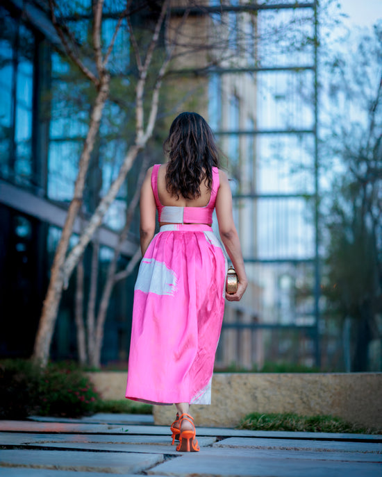 back view of blush pink and ivory printed raw silk skirt midi skirt set with crop top, showing silhouette and pleated structure